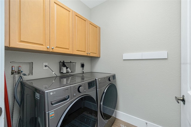 clothes washing area with cabinets, wood-type flooring, and washing machine and clothes dryer