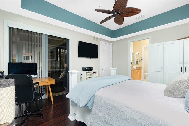 bedroom featuring ceiling fan, dark hardwood / wood-style flooring, and ensuite bath