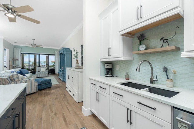 kitchen featuring dishwasher, light stone countertops, sink, and white cabinets