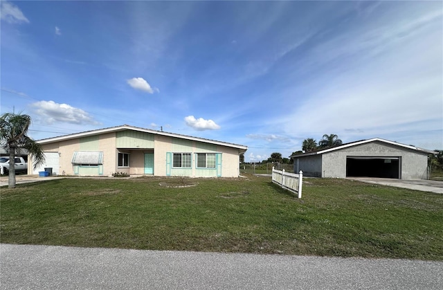 view of front of property with a garage, an outbuilding, and a front lawn