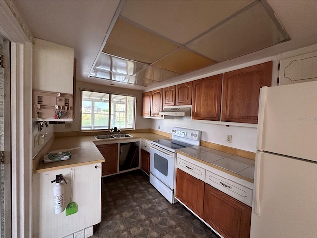 kitchen with a paneled ceiling, sink, and white appliances