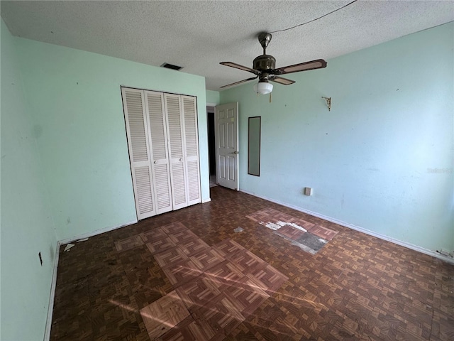 unfurnished bedroom with ceiling fan and a textured ceiling