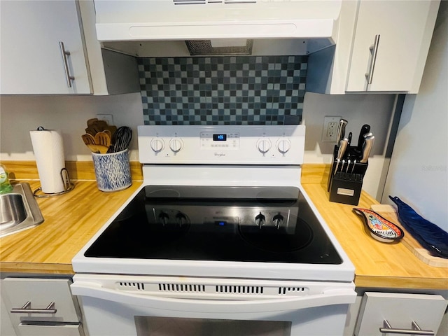 kitchen featuring ventilation hood, decorative backsplash, white cabinets, and electric range