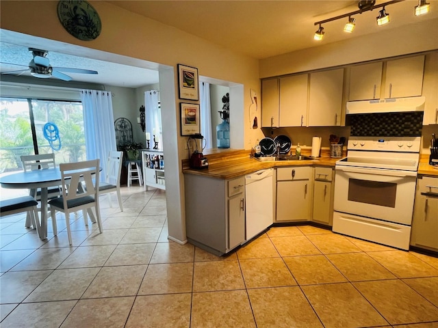 kitchen featuring white appliances, butcher block counters, decorative backsplash, ceiling fan, and light tile patterned floors