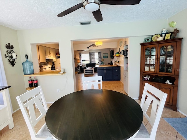 tiled dining room featuring a textured ceiling