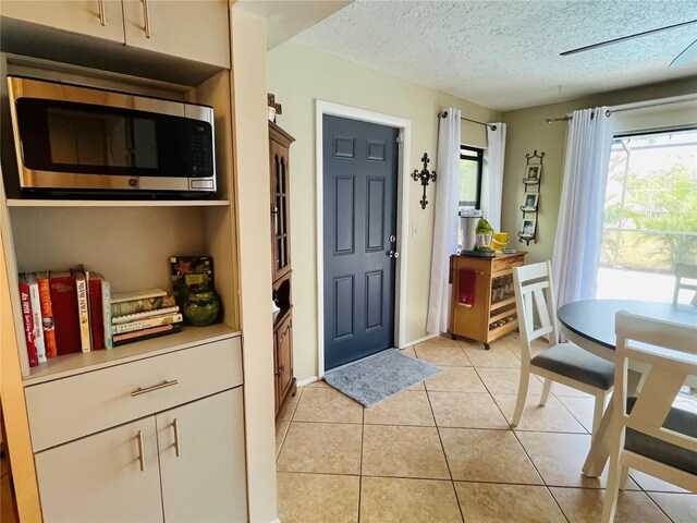 entryway with a textured ceiling and light tile patterned floors