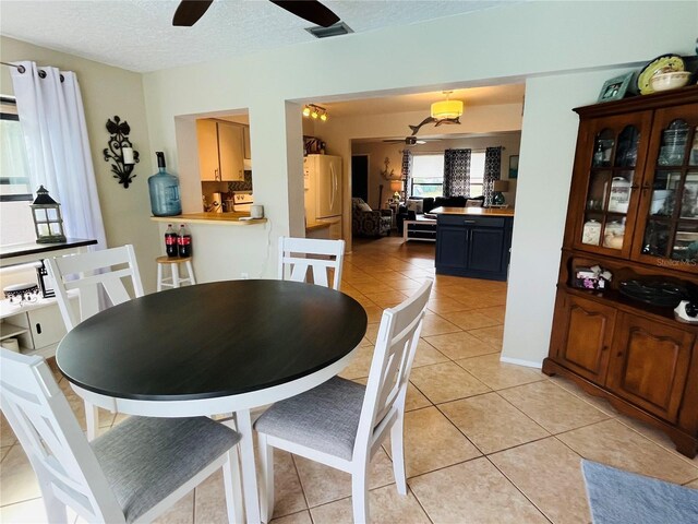 tiled dining room featuring ceiling fan and a textured ceiling