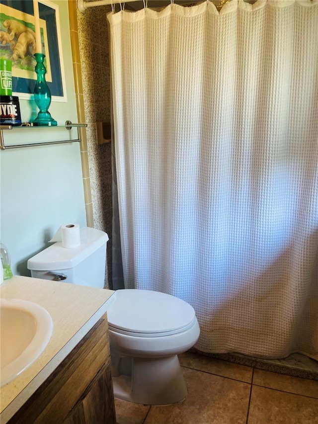 bathroom featuring tile patterned floors, toilet, vanity, and walk in shower