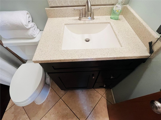 bathroom with toilet, tile patterned flooring, and vanity