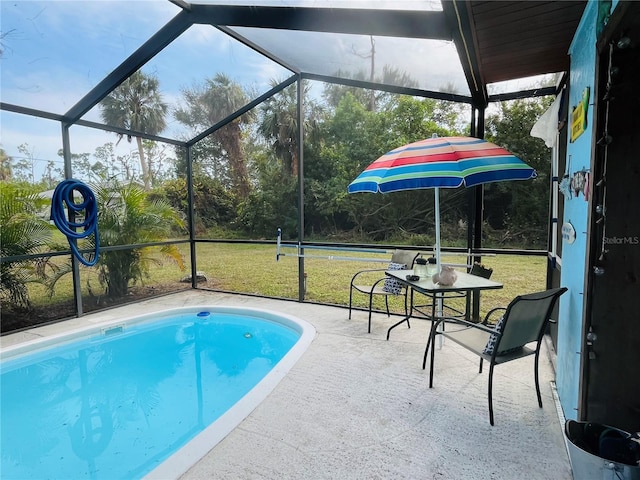 view of swimming pool featuring glass enclosure, a lawn, and a patio