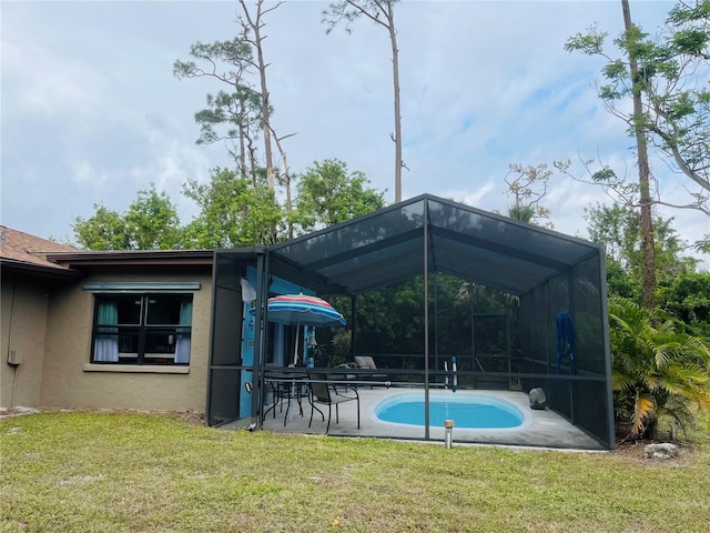 back of house with a lanai, a lawn, and a patio