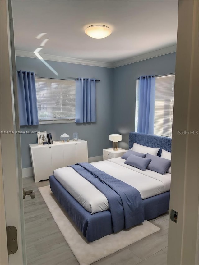 bedroom with light wood-type flooring and ornamental molding