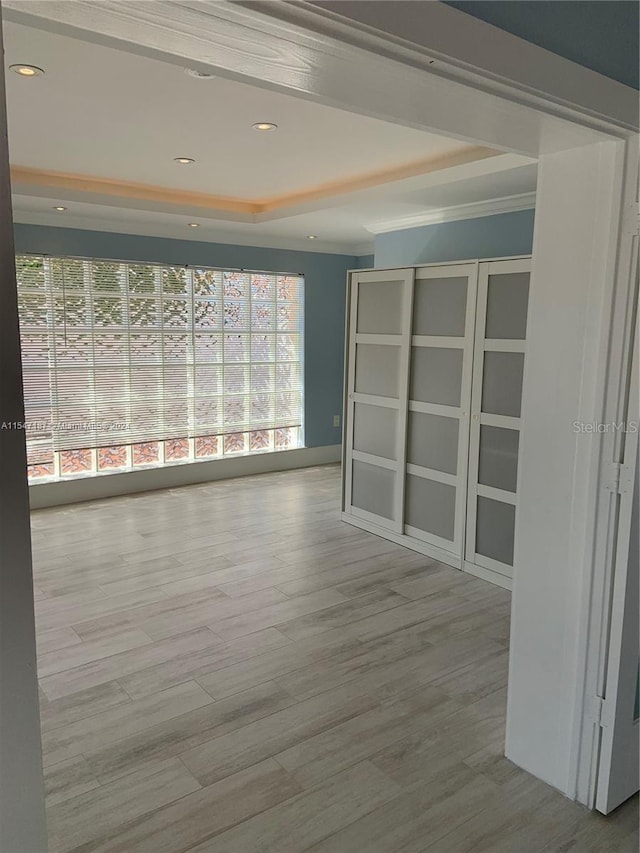 spare room featuring light hardwood / wood-style floors and ornamental molding