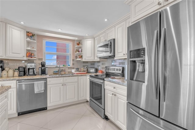 kitchen featuring white cabinets, light stone counters, light tile patterned floors, and stainless steel appliances