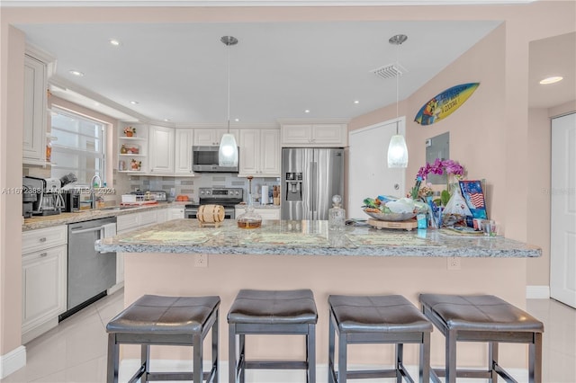 kitchen with sink, stainless steel appliances, light tile patterned floors, light stone counters, and white cabinets