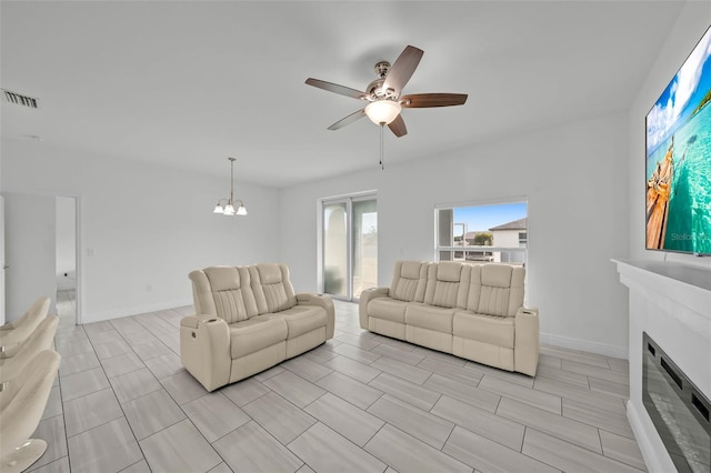 living room featuring ceiling fan with notable chandelier