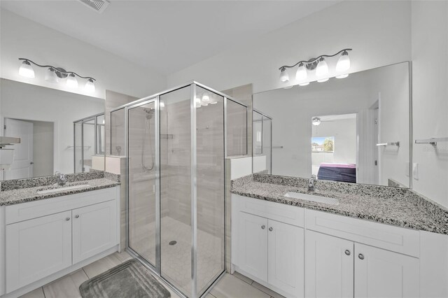 bathroom featuring tile patterned flooring, vanity, and walk in shower