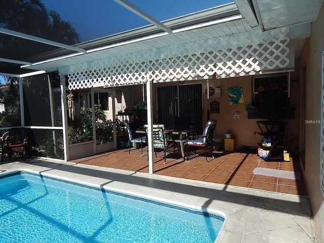 view of swimming pool featuring glass enclosure and a patio