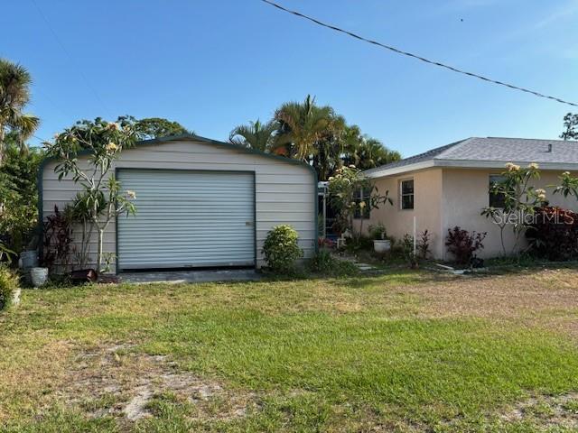 exterior space with an outbuilding, a garage, and a lawn