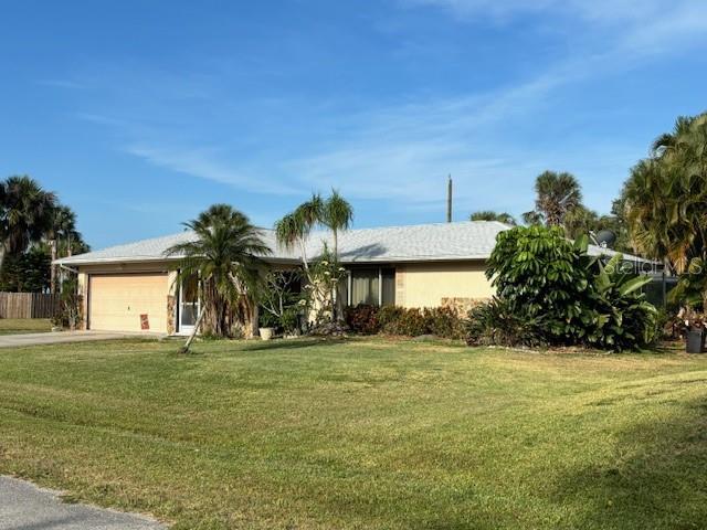 ranch-style home with a garage and a front lawn