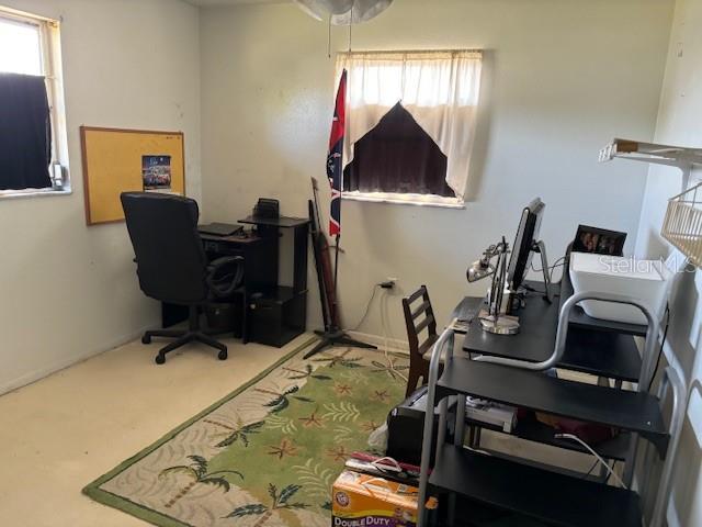 carpeted office featuring baseboards