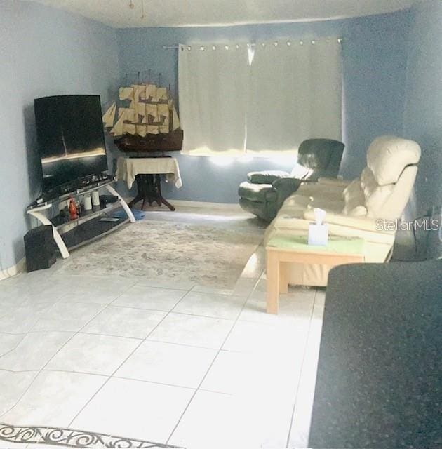 living room featuring tile patterned flooring and baseboards