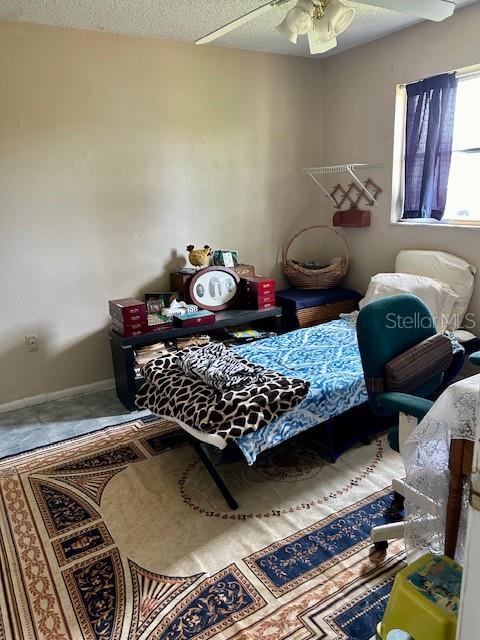 bedroom featuring ceiling fan and a textured ceiling