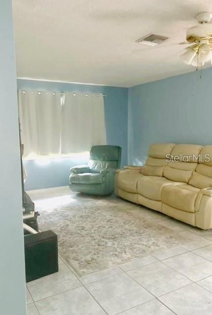 living area with ceiling fan, tile patterned flooring, and visible vents