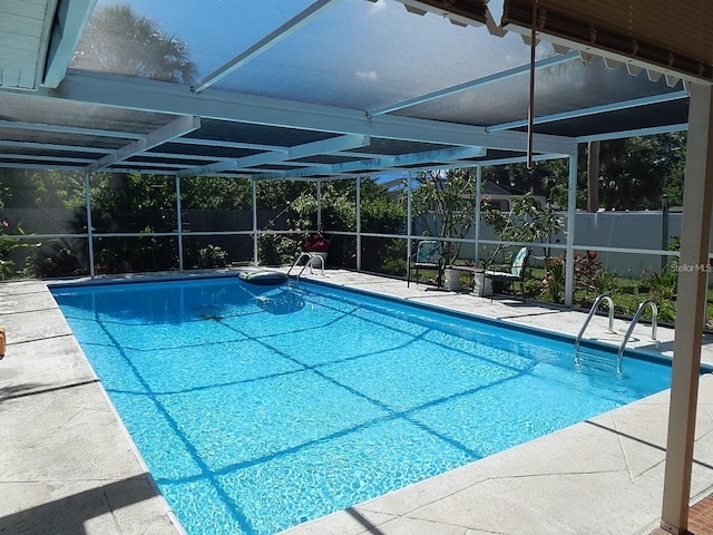 view of swimming pool with a patio area, a fenced backyard, and glass enclosure