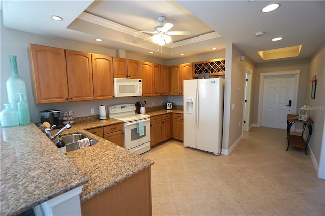 kitchen with a raised ceiling, kitchen peninsula, light stone countertops, and white appliances