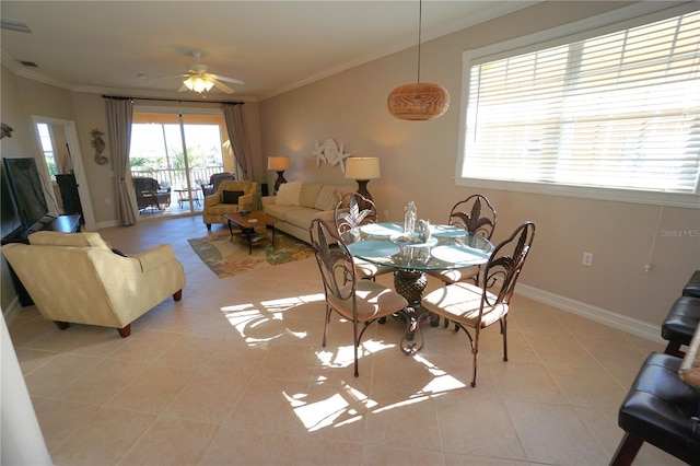 tiled dining space with ceiling fan and ornamental molding