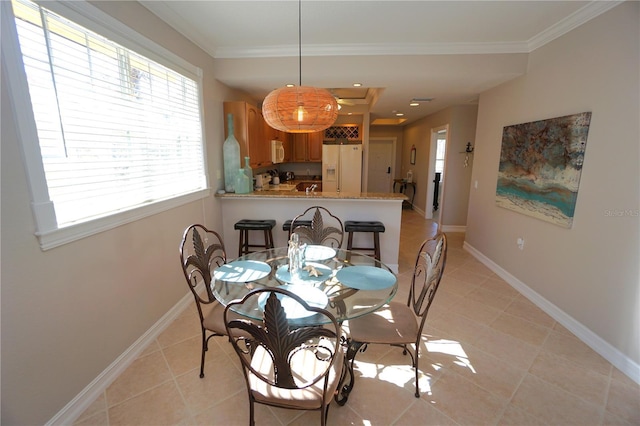 dining room with light tile patterned floors and crown molding