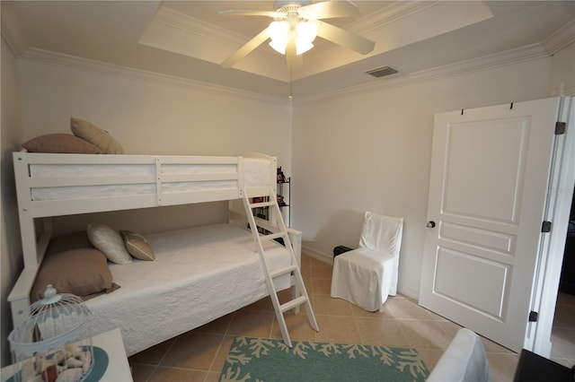 bedroom featuring tile patterned floors, ceiling fan, crown molding, and a tray ceiling