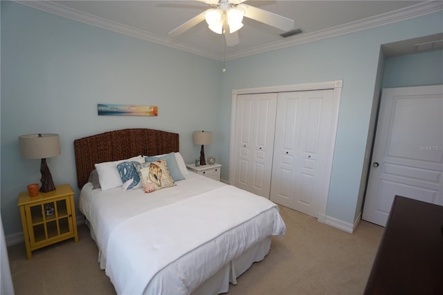 carpeted bedroom with ceiling fan, a closet, and crown molding