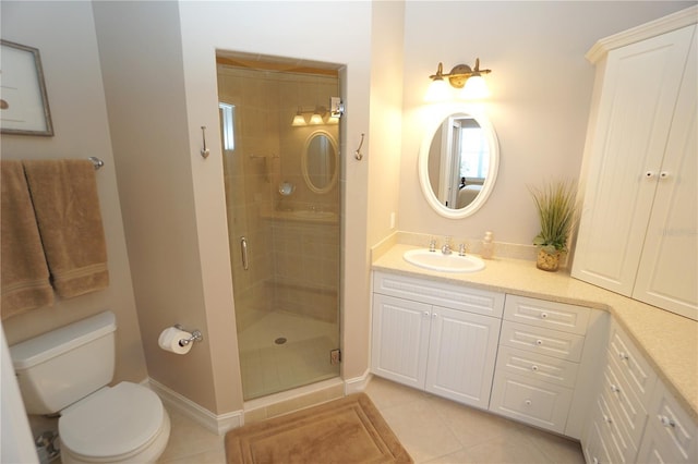 bathroom featuring tile patterned floors, vanity, a shower with shower door, and toilet