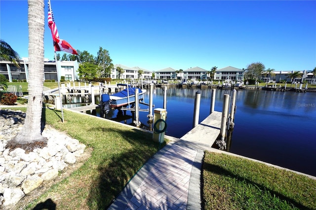 view of dock featuring a water view and a lawn