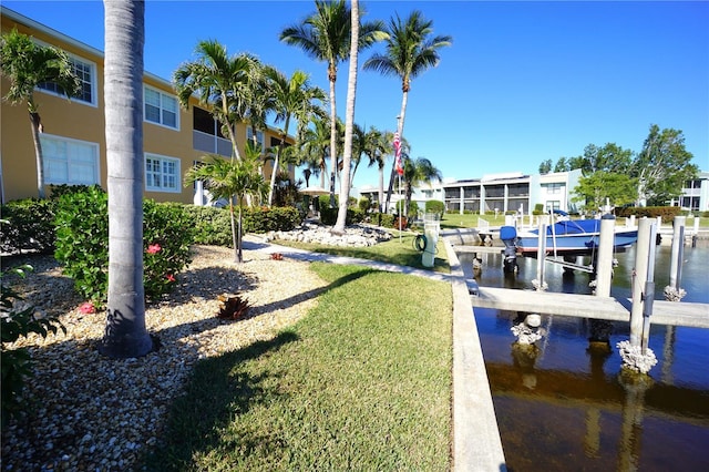 dock area with a water view and a yard