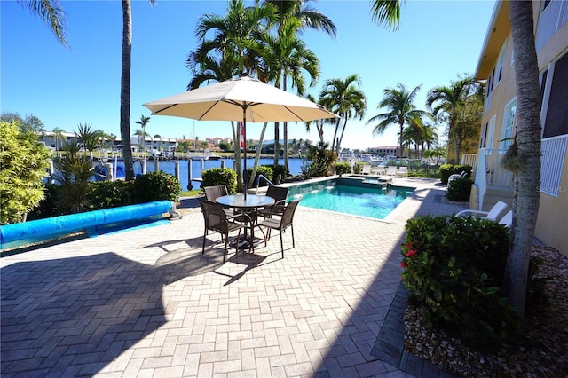 view of swimming pool with a water view and a patio area