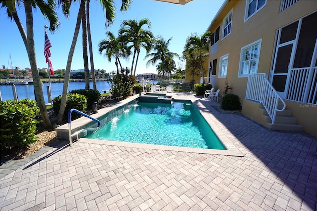 view of pool with a water view and a patio