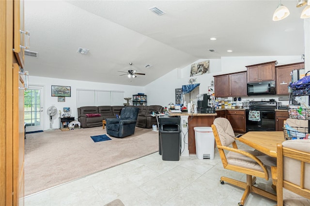 interior space featuring kitchen peninsula, lofted ceiling, black appliances, light carpet, and a kitchen bar