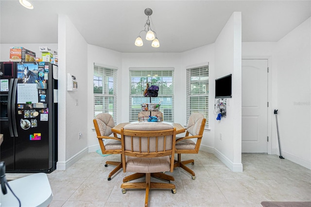 tiled dining room featuring an inviting chandelier