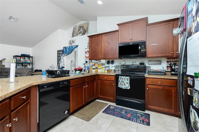 kitchen featuring vaulted ceiling, sink, light tile patterned floors, black appliances, and kitchen peninsula