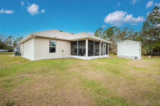 rear view of property with a yard, a shed, and a sunroom