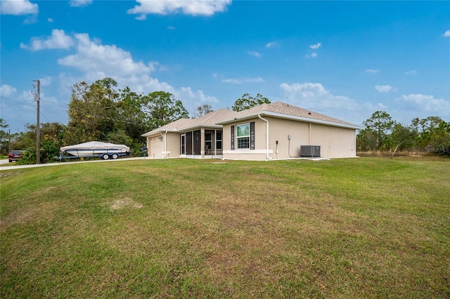 back of house with central AC unit, a yard, and a sunroom