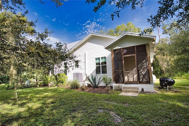 view of front of home featuring a front lawn and a sunroom