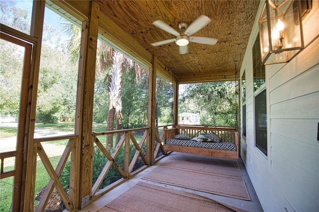 unfurnished sunroom featuring a wealth of natural light, ceiling fan, and wood ceiling