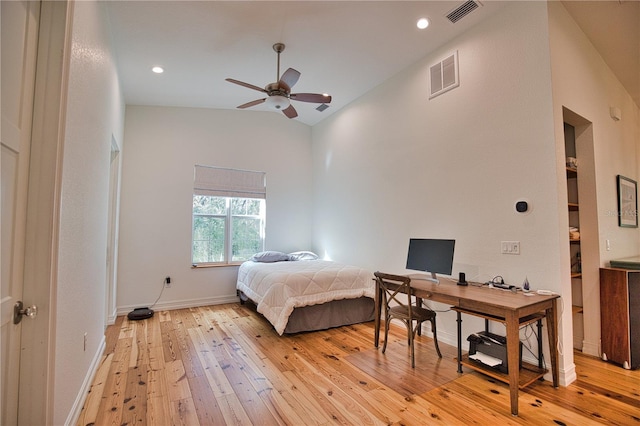 bedroom featuring light hardwood / wood-style floors, high vaulted ceiling, and ceiling fan