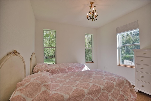 bedroom featuring multiple windows and a chandelier