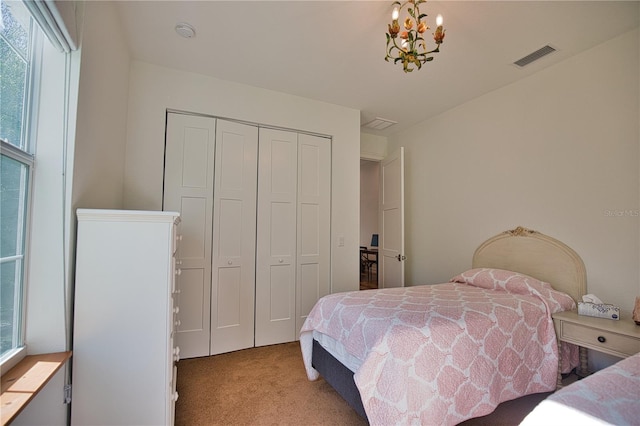 carpeted bedroom featuring a chandelier, multiple windows, and a closet