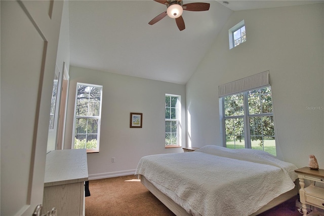 carpeted bedroom with ceiling fan and high vaulted ceiling